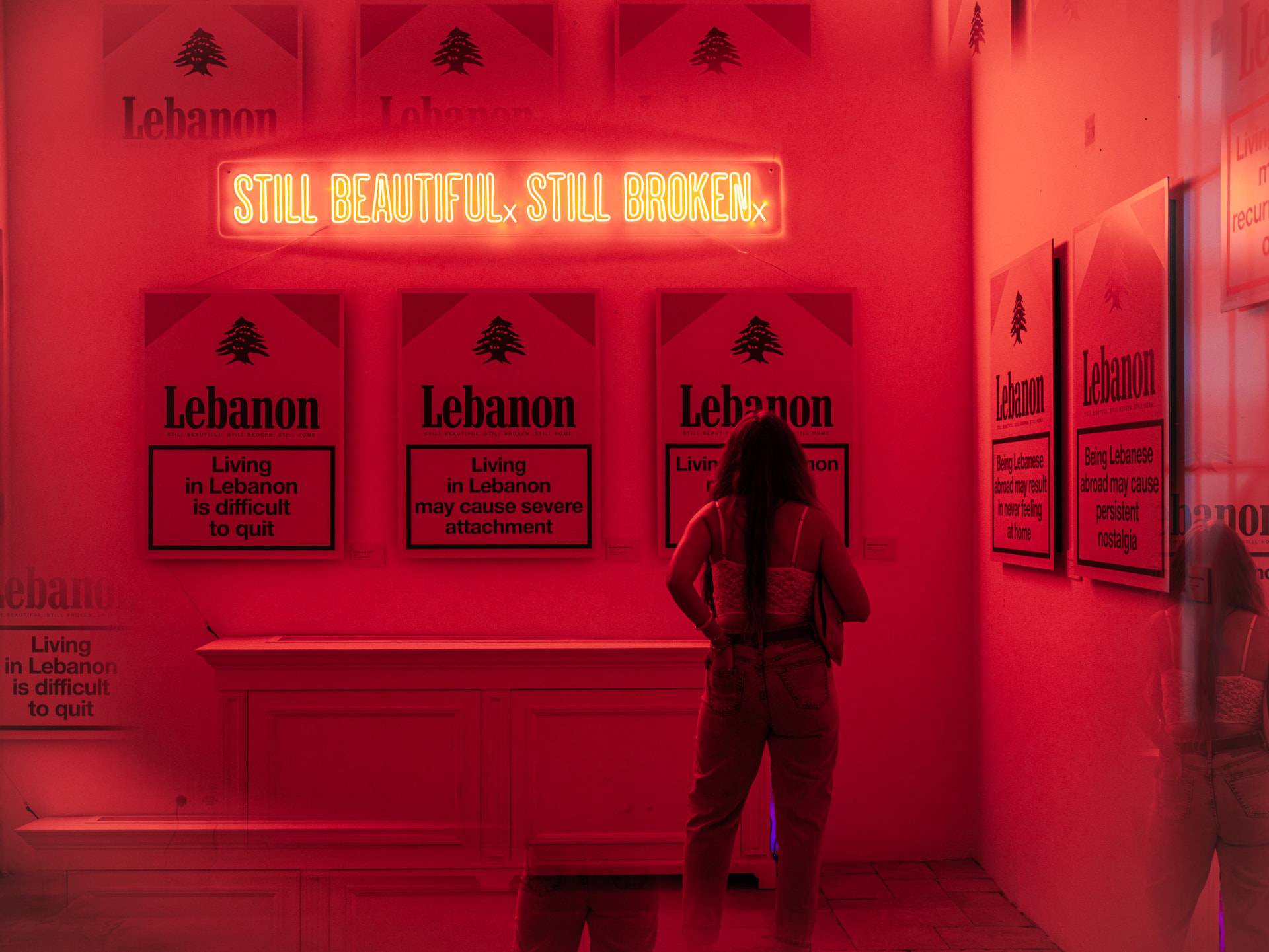 Neon — Still Beautiful. Still Broken. above the twelve prints. Photo Yoan Zoghbi.